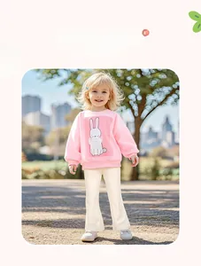Outdoor model shot of girl in pink rabbit print sweatshirt and cream flared pants set