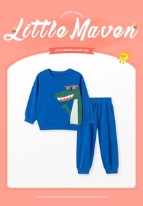Detail of blue toddler tracksuit featuring a green cartoon crocodile on a long-sleeve top
