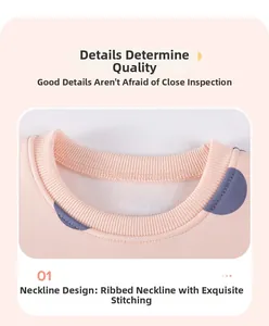 Détail d'un sweat rose à pois avec encolure côtelée et coutures de précision