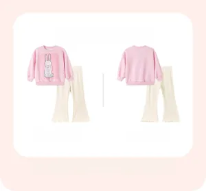 Close-up of pink girls' sweatshirt with bunny print and off-white flared trousers
