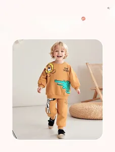 Detail of toddler ginger yellow tracksuit featuring cartoon lion and safari print graphics