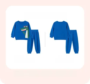 Detail of blue toddler tracksuit featuring a cartoon crocodile print on a sweatshirt