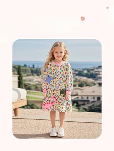 Détail d'une robe fleurie en coton à manches longues pour fille avec appliqué dinosaure