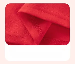 Détail macro de la double couture lisse sur l'ourlet de la robe rouge pour fille
