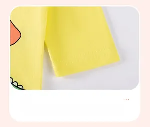 Close-up of a yellow cotton kid's T-shirt cuff with a colorful cartoon dinosaur pattern