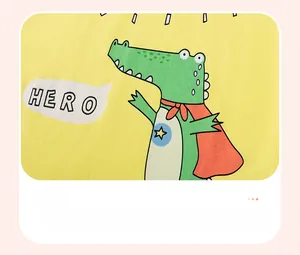 Close-up of yellow cotton toddler shirt with green crocodile superhero print detail