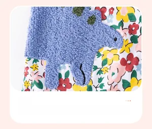 Gros plan sur la broderie dinosaure 3D sur tissu en coton fleuri pour bébé