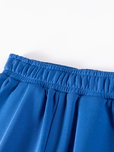 Detail of dark blue boys' joggers showing the elastic waistband and knit fabric texture