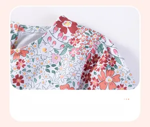 Close-up of pleated shoulder design on a white floral print long sleeve cotton girls dress