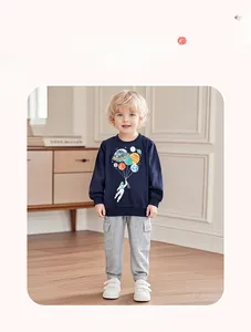 Boy's space print sweatshirt and grey cargo pants outfit set shown in a cozy home setting