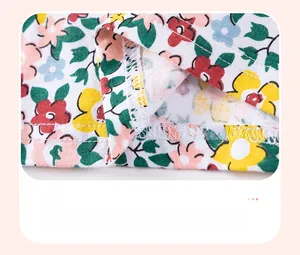 Gros plan détaillé sur les coutures de l'ourlet et le motif floral de la robe en coton