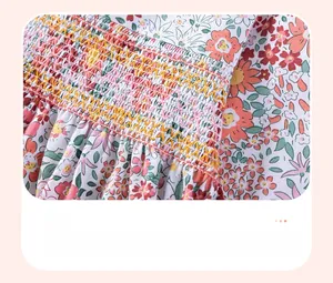 Close-up of smocking embroidery and vibrant floral print on soft cotton girls' dress