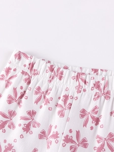 Detailansicht der Mädchen-Winterhose mit elastischem Bund und rosa Blumen-Schleifen-Print