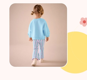 Back view of girl's cotton autumn set with blue sweatshirt and striped flared pants