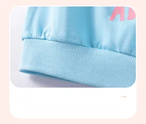 Detail of light blue striped cotton garment showing elastic ribbed hem and pink design