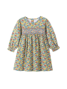 Long-sleeved cotton girl dress featuring colorful floral prints and smocking detail