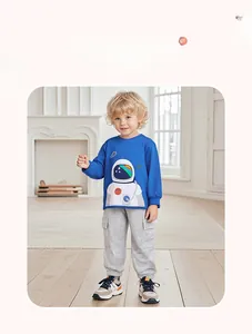 Blue astronaut sweatshirt and grey jogger pants set for young boys in a cozy room