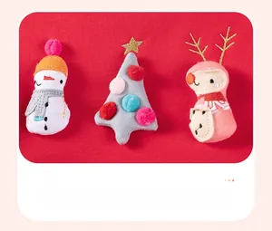Detail of red festive dress featuring 3D embroidered snowman and Christmas tree plush toys