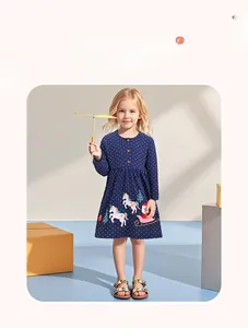 Dettaglio dell'abito natalizio blu scuro per bambine con pois bianchi e stampe di unicorni