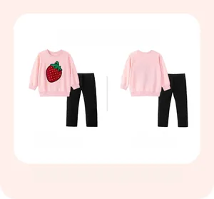 Vue à plat d'un sweat à fraises rose pour fille et d'un pantalon noir ensemble enfant