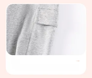Detail of grey knitted boy's joggers featuring a functional cargo pocket and soft texture