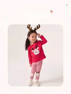 Détail d'un ensemble de Noël pour enfant avec broderie de cerf et motifs à rayures