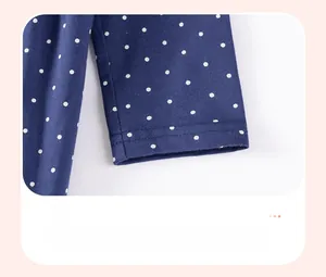 Dettaglio della manica dell'abito blu scuro a pois con cuciture di precisione a doppio ago