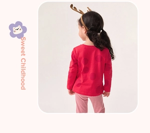 Détail du haut à pois rouges et pantalon rayé rouge pour filles avec bois de Noël