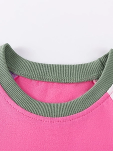 Pink cotton girls long sleeve dress with green ribbed neckline and detailed stitching