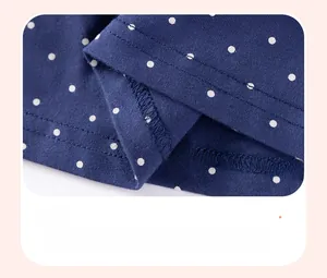 Dettaglio dell'orlo del vestito blu navy a pois con cuciture a doppio ago di alta qualità
