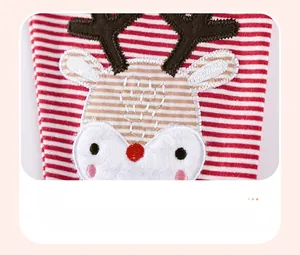 Détail de broderie renne sur tissu tricoté à rayures rouges et blanches de Noël