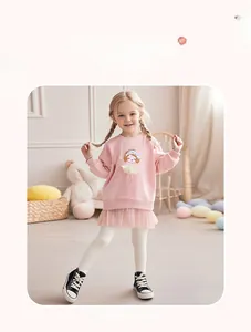 Detail van roze sweatshirtjurk met lange mouwen, cartoonprint en witte legging