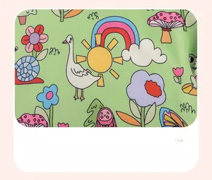 Detail of soft green fabric featuring vibrant forest cartoon animal and nature prints