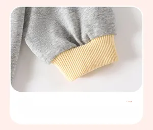 Close-up of gray long-sleeve sweatshirt with yellow contrast ribbed cuffs for girls