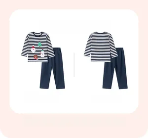 Dettaglio pigiama natalizio da bambino a righe con stampe festive di cartoni animati
