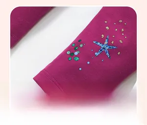 Detail of rose pink cotton kids pants featuring sequined starfish and polka dot pattern