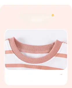 Detailed view of the ribbed crew neckline with orange stripes on soft cotton knitwear