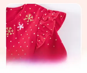 Close-up of red cotton dress shoulder with gold polka dots and ruffled sleeve detail
