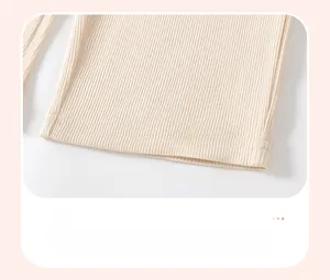 Detail of ribbed knit cuffs and flat double-needle stitching on beige toddler trousers
