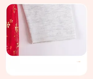 Detail of grey cotton cuff stitching and red tulle with golden snowflake prints
