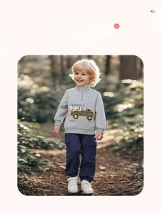 Detail of grey half-zip sweatshirt with cartoon animal embroidery and blue cargo pants