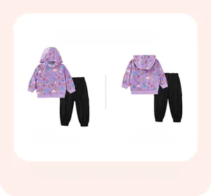 Flat lay of purple dinosaur hoodie and black cargo pants set for toddler girls
