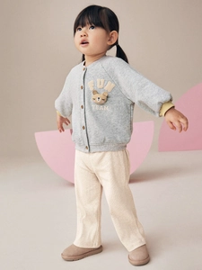 Cute girls' gray FUN TEAM sweatshirt with bear patch and beige corduroy trousers outfit