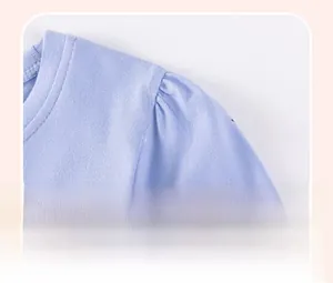 Dettaglio delle balze sulla spalla di un vestito in maglia di cotone lilla per bimba