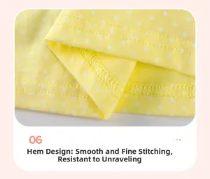 Détail de l'ourlet à double couture sur une robe jaune à pois pour filles