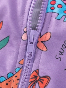 Close-up of a purple hooded sweatshirt featuring a resin zipper and cartoon dinosaur prints