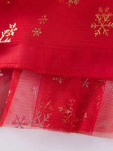 Girl's red Christmas dress featuring layered tulle with golden snowflake patterns