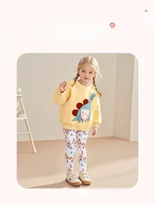 Détail ensemble fille avec sweat-shirt dinosaure jaune et legging à motifs colorés