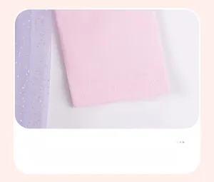 Détail des manches en tricot rose avec tulle à paillettes violettes et paillettes dorées