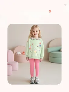 Detail eines hellgrünen Mädchen-Sweatshirts mit Blumenkragen und rosa schmaler Hose